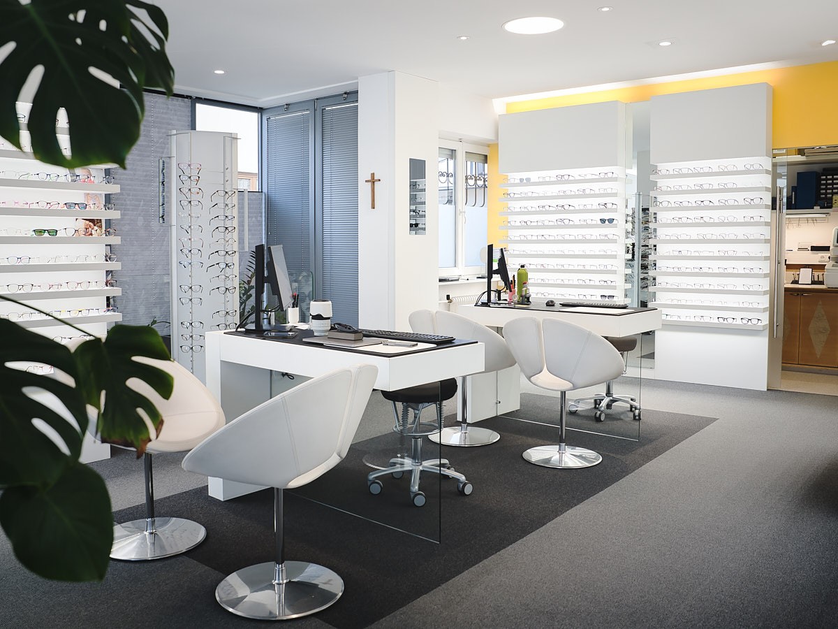 Innenraumfotografie eines modernen Optikergeschäfts mit heller Gestaltung, Brillenpräsentation und klaren Linien.
