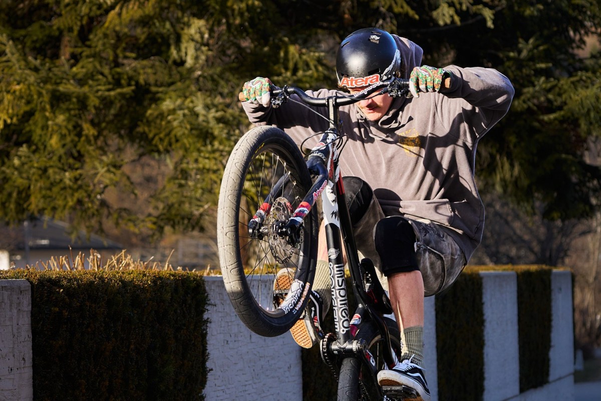 Actionreiche Trial-Bike-Fotografie eines Mountainbikers beim Sprung auf ein Hindernis mit präzisem Fokus.