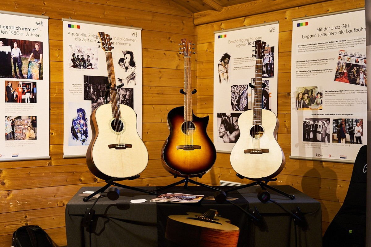 Authentic photography of a guitar-making exhibition with handcrafted instruments and warm lighting.
