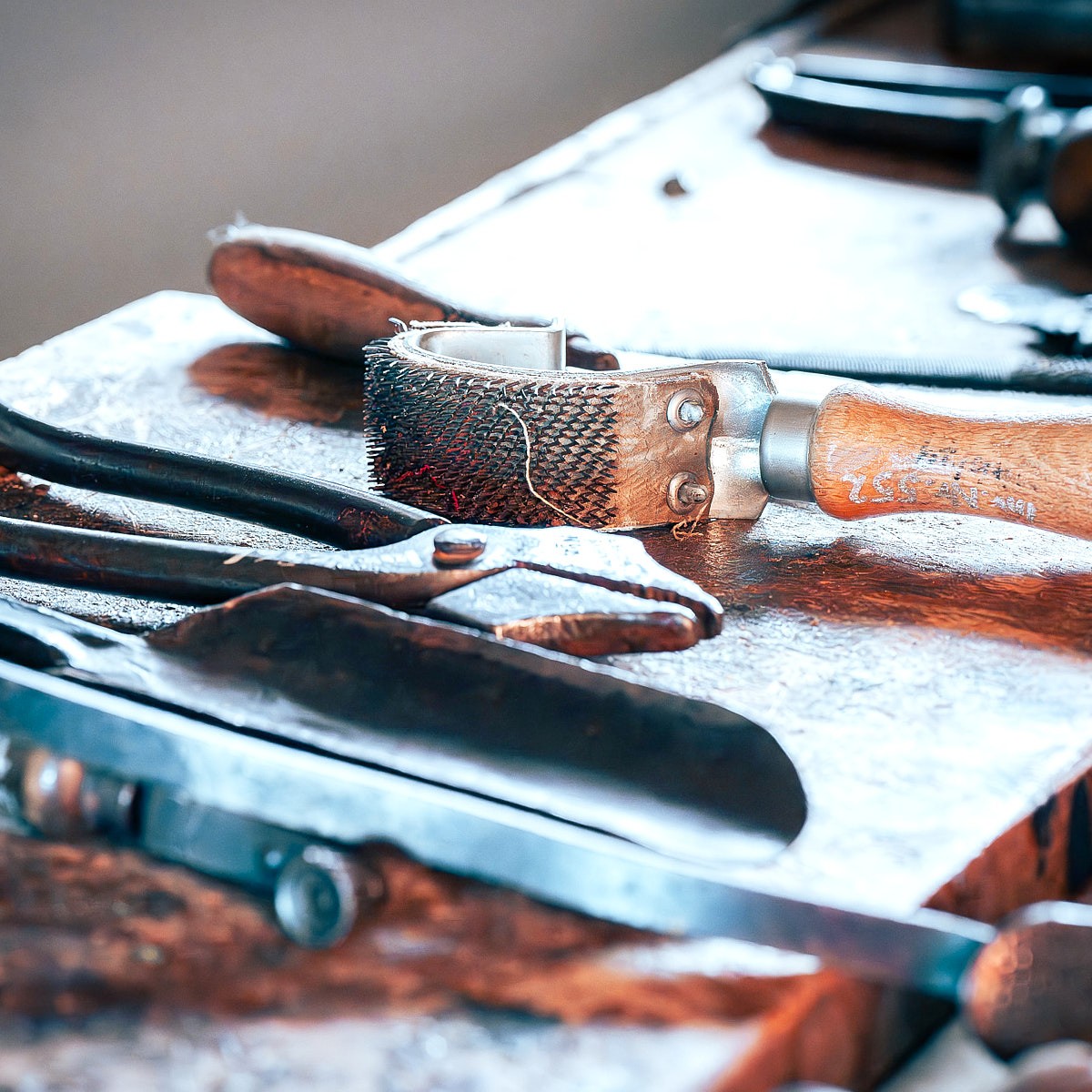 Atmospheric craftsmanship photography with traditional tools, rich detail, and natural workshop lighting.