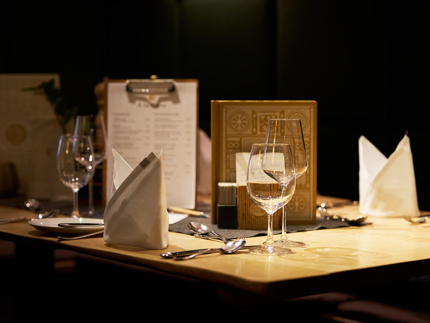 Stimmungsvolle Imagefotografie eines gedeckten Restauranttisches mit warmem Licht, elegantes Ambiente für Gastronomie und Markenerlebnis