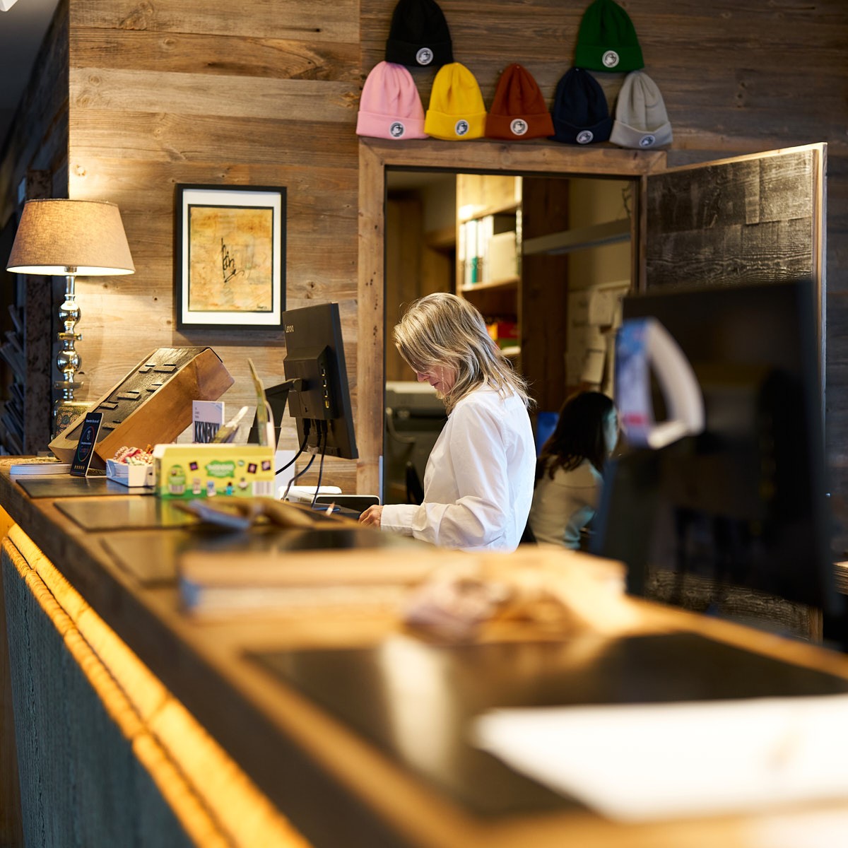 Rezeption in einem alpinen Hotel mit gemütlichem Ambiente und authentischem Service – Tourismusfotografie für Hotellerie.
