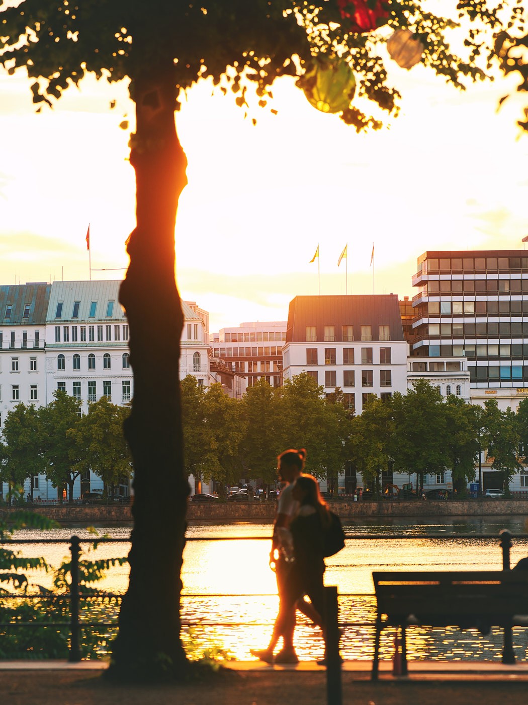 Businessfotografie an der Alster in Hamburg bei Sonnenuntergang – urbane Stimmung mit Spaziergängern und moderner Architektur.
