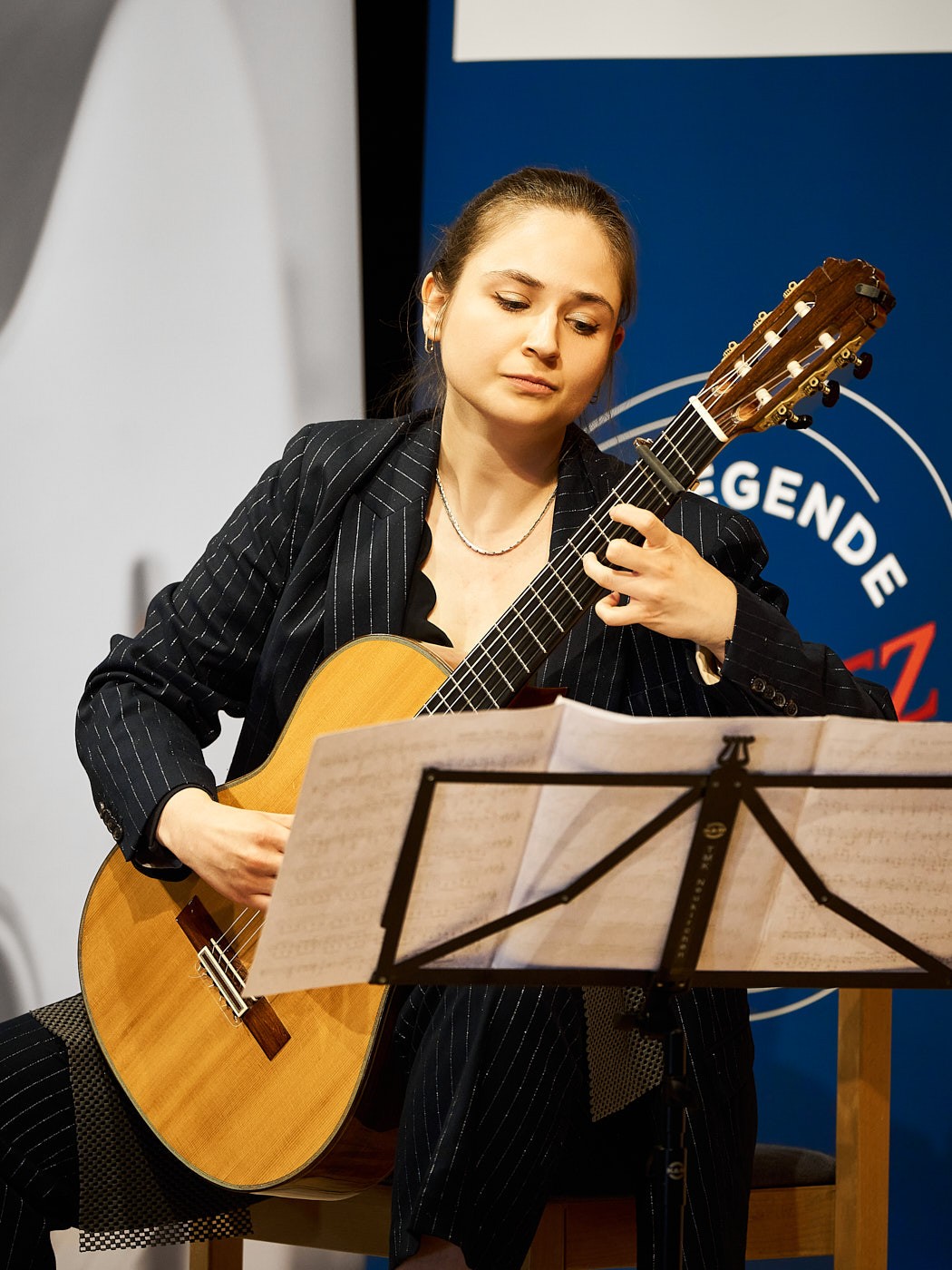 Schülerin einer Meisterklasse bei einem Konzert mit klassischer Gitarre – authentische Eventfotografie einer Musikveranstaltung.