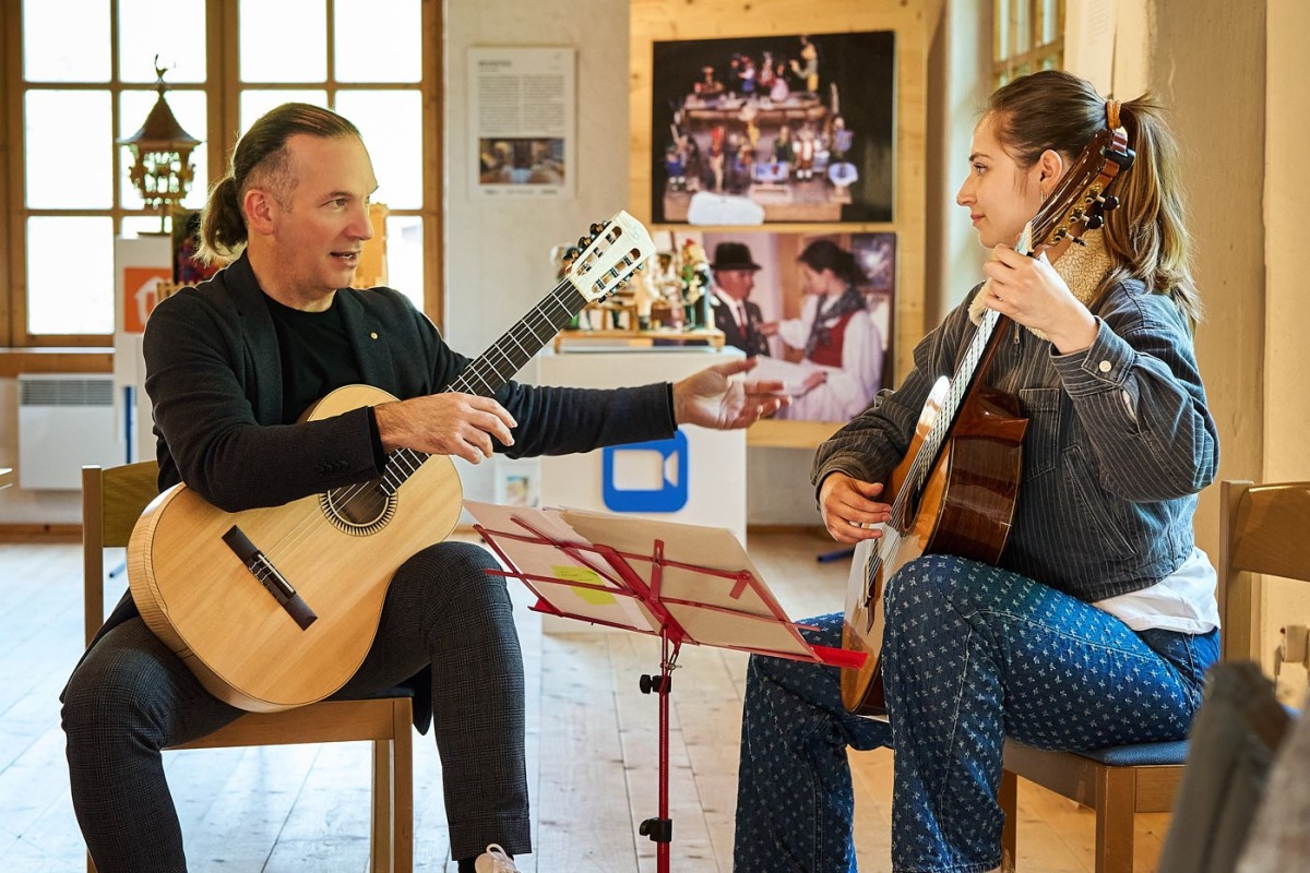 Gitarren-Meisterklasse mit Lehrer und Schülerin – Eventfotografie während einer musikalischen Unterrichtseinheit.