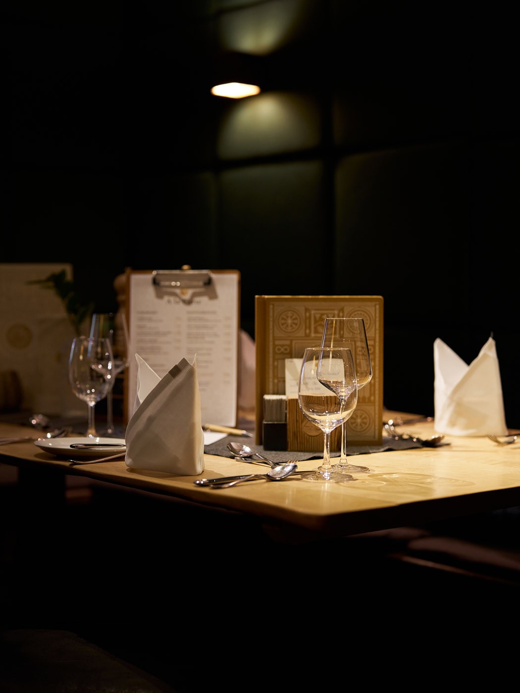 Stimmungsvolle Imagefotografie eines gedeckten Restauranttisches mit warmem Licht, elegantes Ambiente für Gastronomie und Markenerlebnis