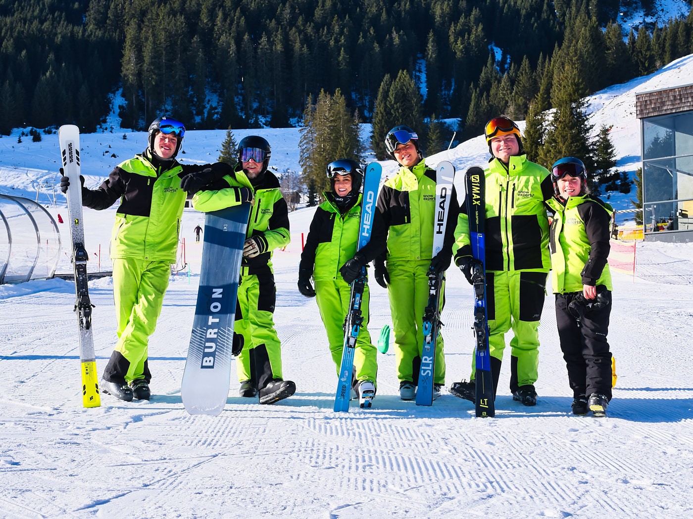Authentische Imagefotografie eines Skilehrer Teams auf der Piste, starke Markenpräsenz und Teamspirit im alpinen Wintersetting