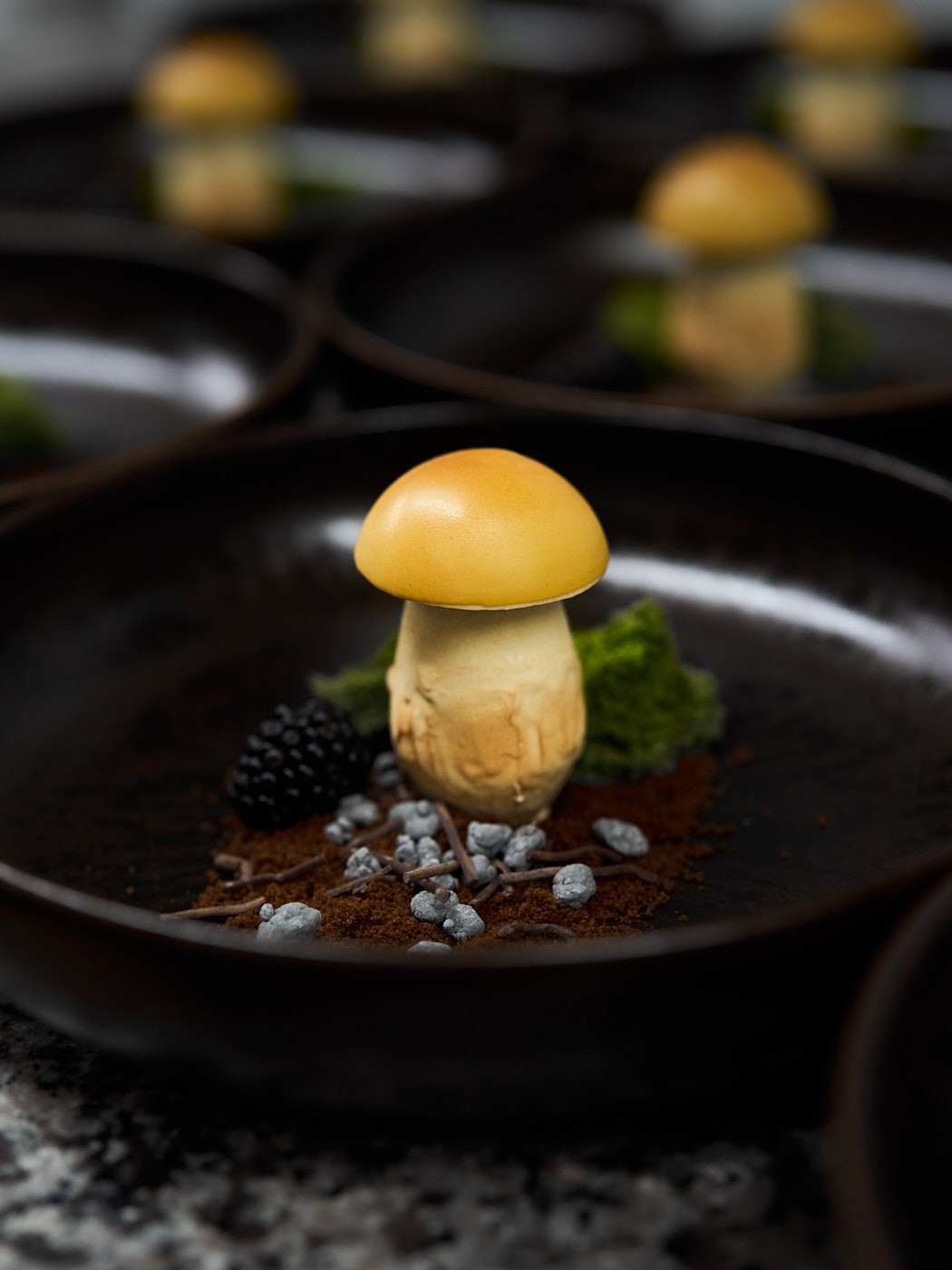 Foodfotografie eines kunstvoll angerichteten Dessertpilzes mit Beeren und Texturen, detailreich inszeniert.